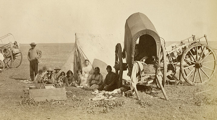 Historical photograph showing Red River carts and families on the plains